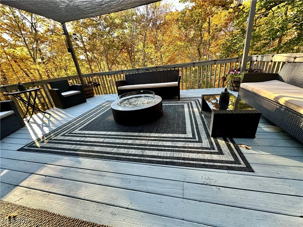 Wooden deck featuring an outdoor living space with a fire pit