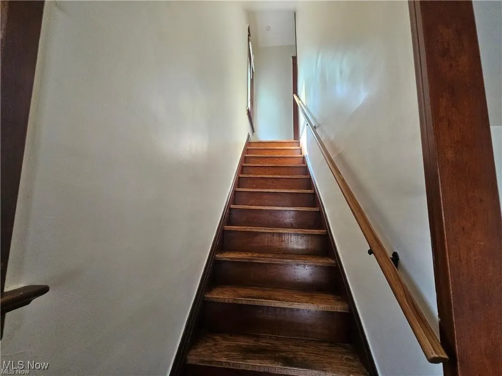 Staircase going upstairs, featuring solid wood stairs