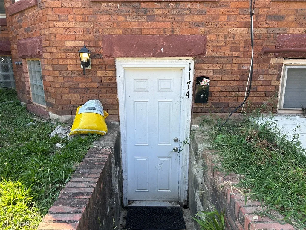 Entrance to property featuring brick siding