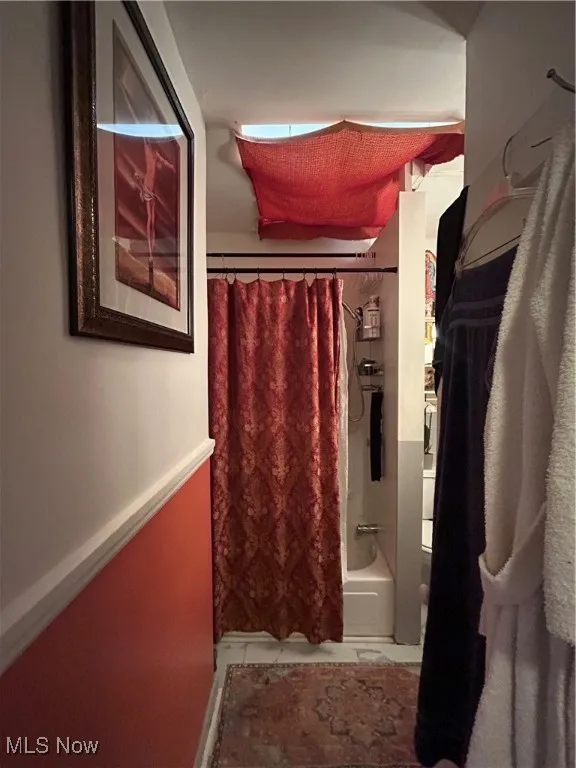 Bathroom featuring shower / bath combination with curtain