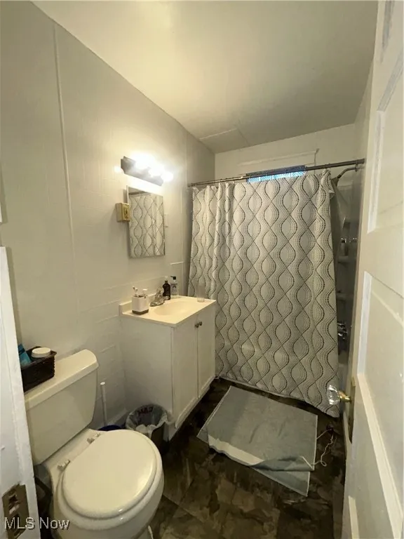 Bathroom with shower / tub combo with curtain and vanity