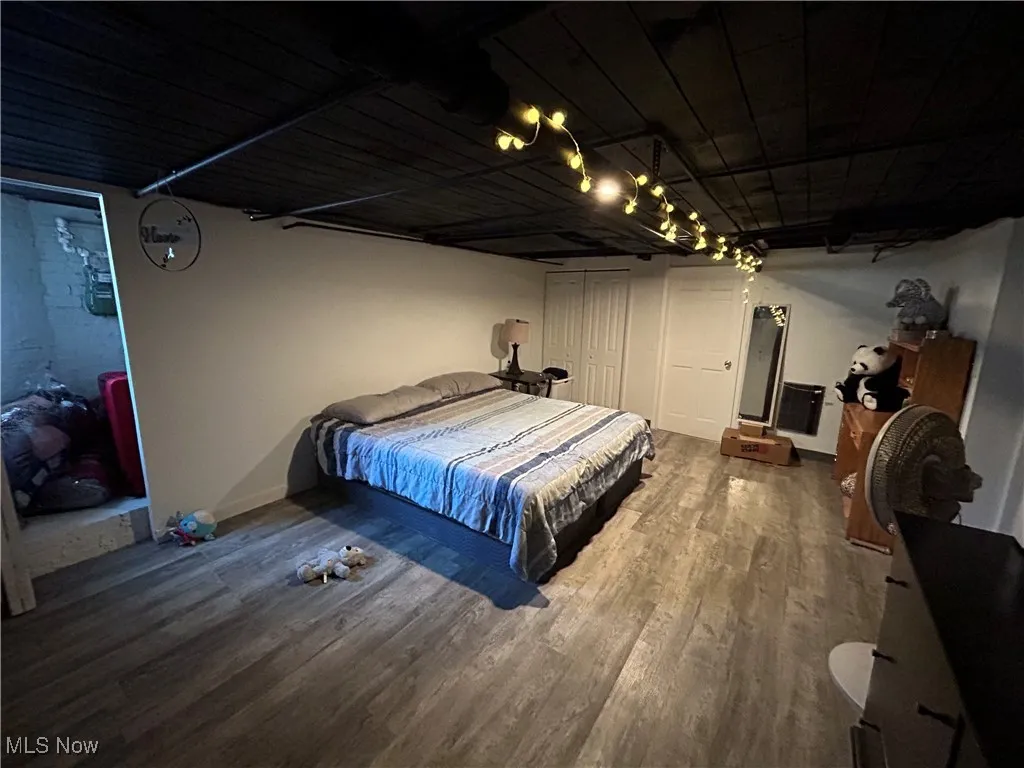 Bedroom with wood finished floors and a closet