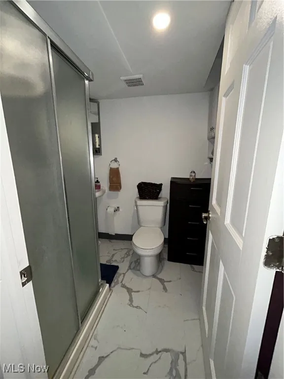 Full bathroom with a shower stall and light marble finish floors