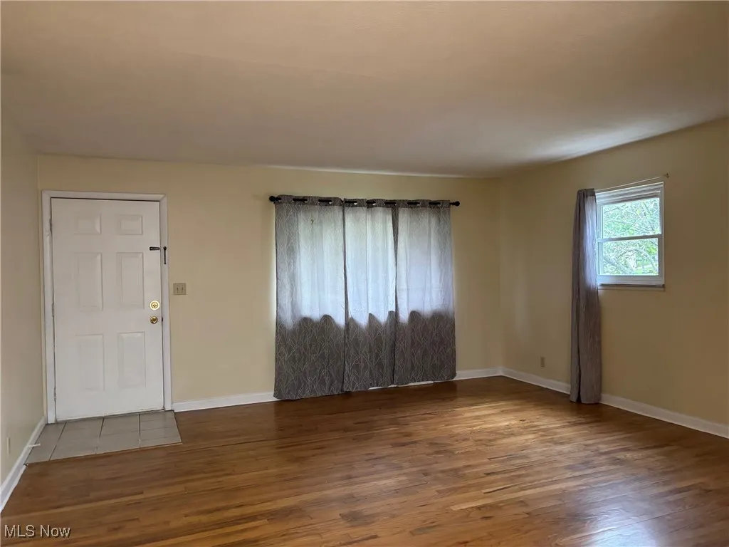 Foyer entrance with wood finished floors and baseboards