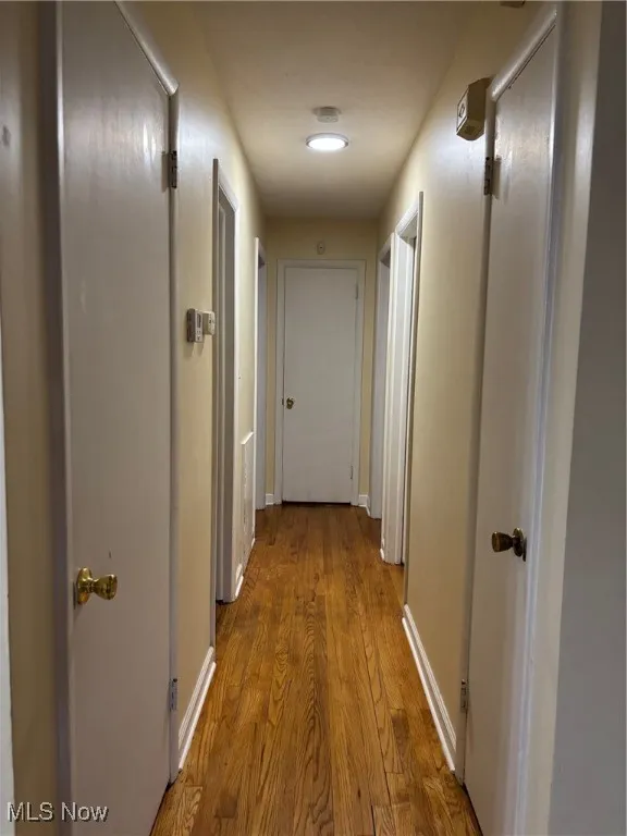 Corridor featuring wood finished floors and baseboards
