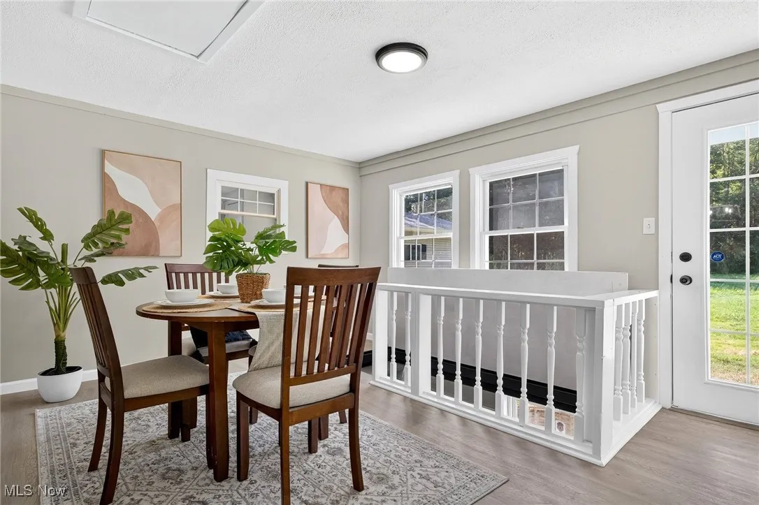 Dining space with light wood-style flooring and a textured ceiling