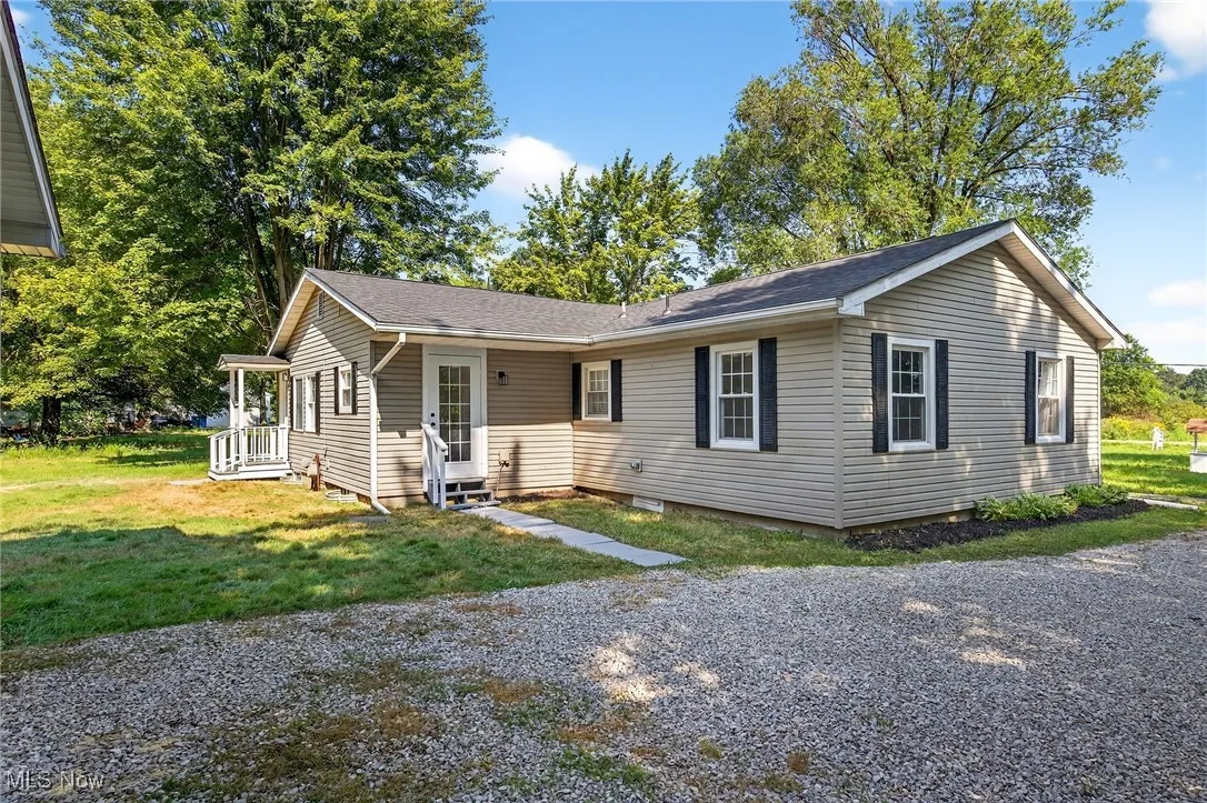 View of front of home featuring a front lawn and roof with shingles