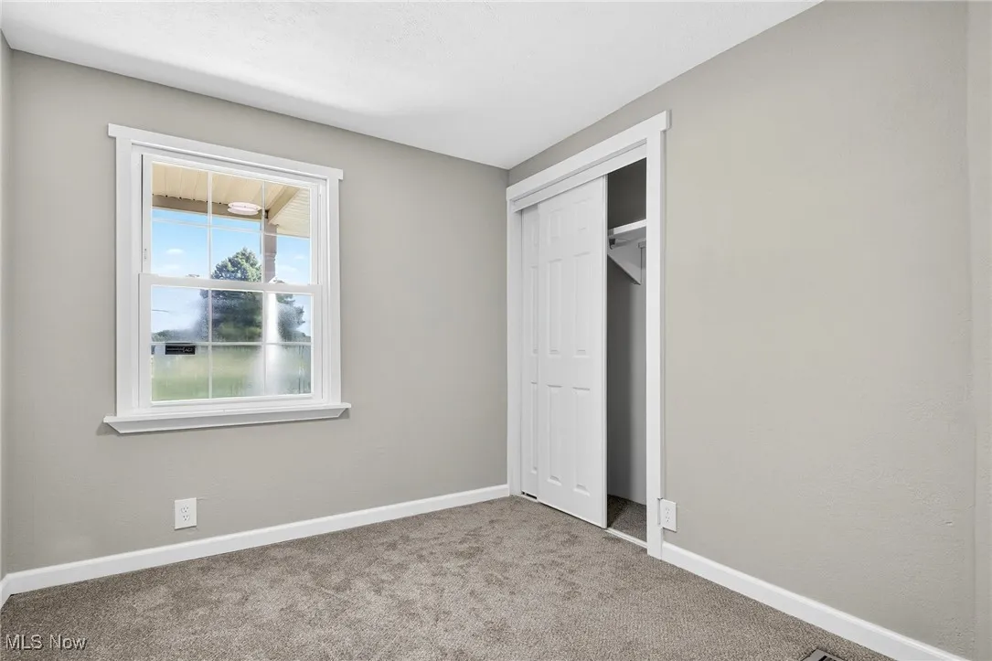 Unfurnished bedroom with carpet flooring and a closet