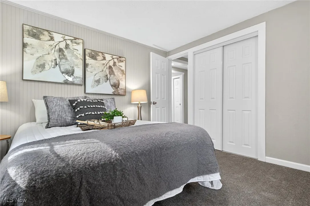 Bedroom featuring dark colored carpet and a closet