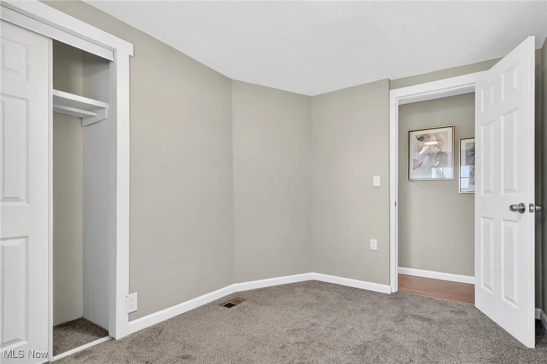 Unfurnished bedroom with carpet and a closet