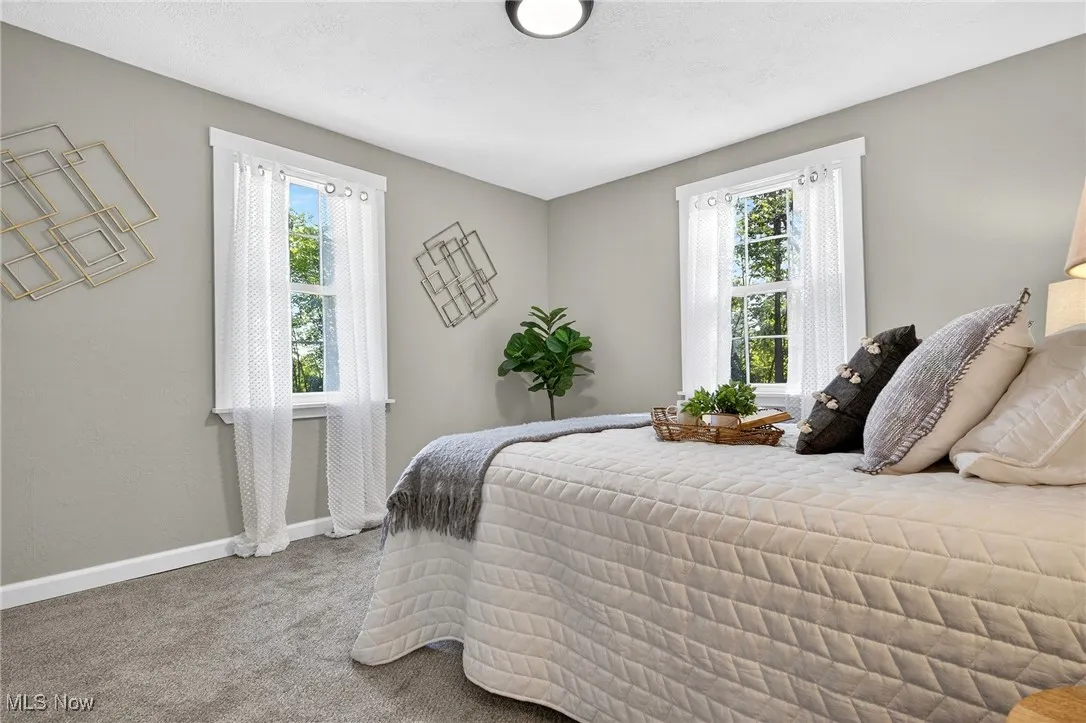 Bedroom featuring light carpet and baseboards