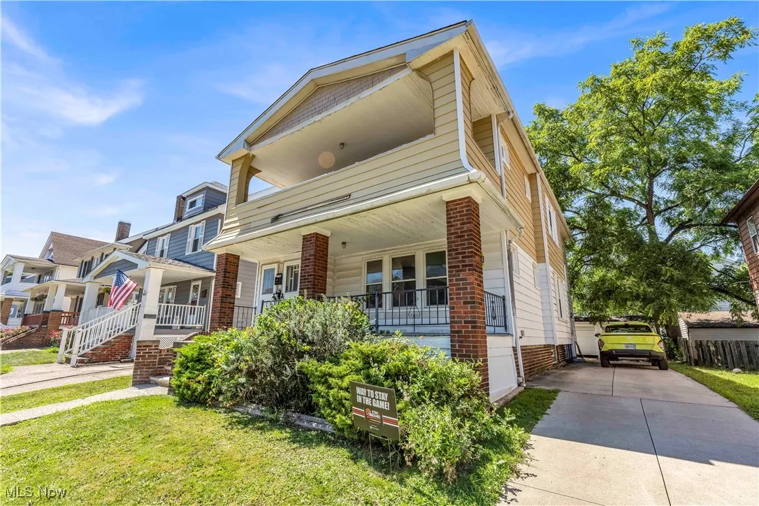 View of front facade featuring a porch, driveway, and a front yard