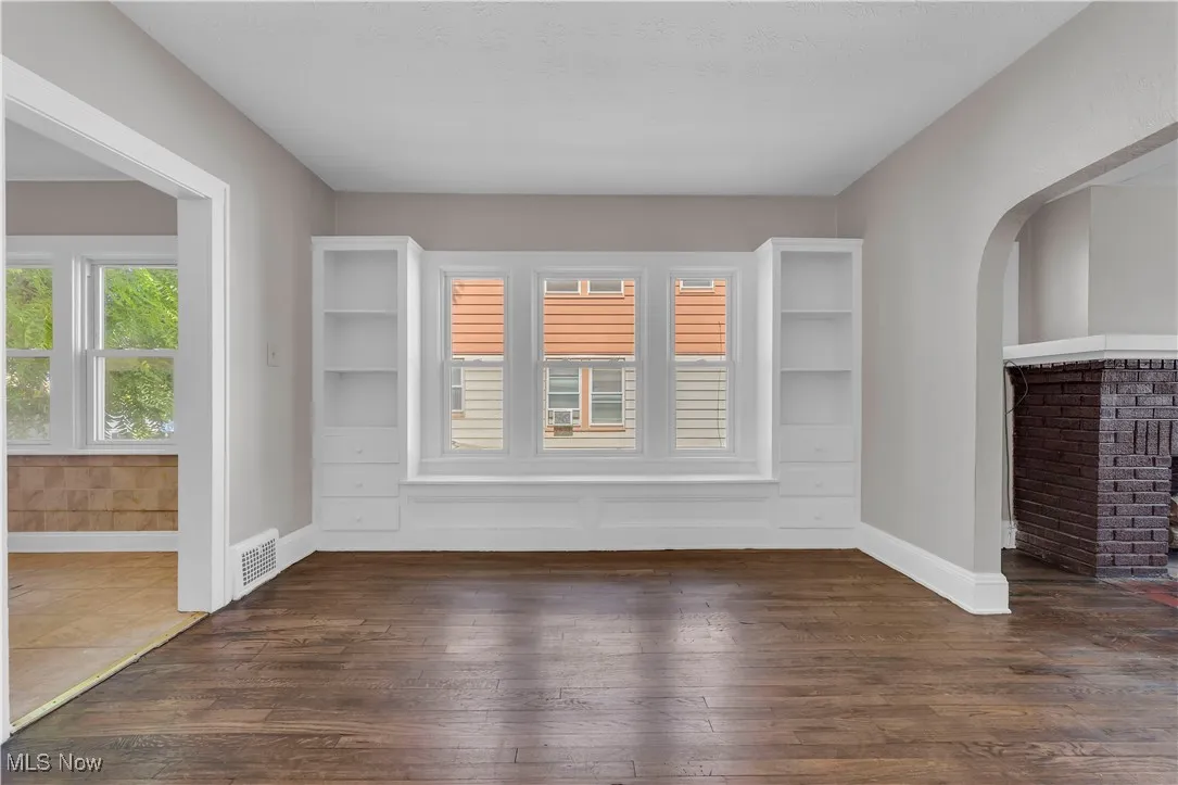 Spare room featuring plenty of natural light and dark wood-style flooring