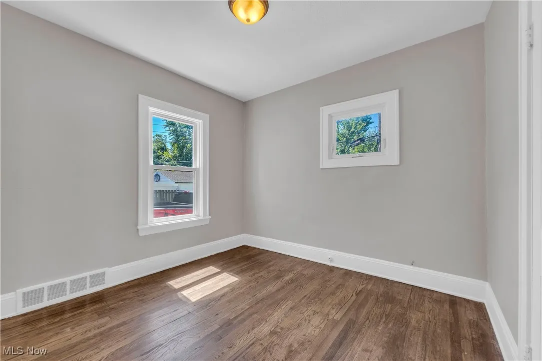 Unfurnished room featuring wood finished floors and baseboards