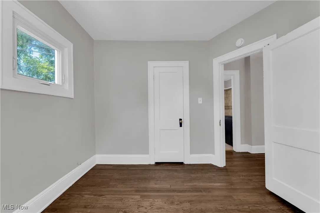 Spare room with dark wood finished floors and baseboards