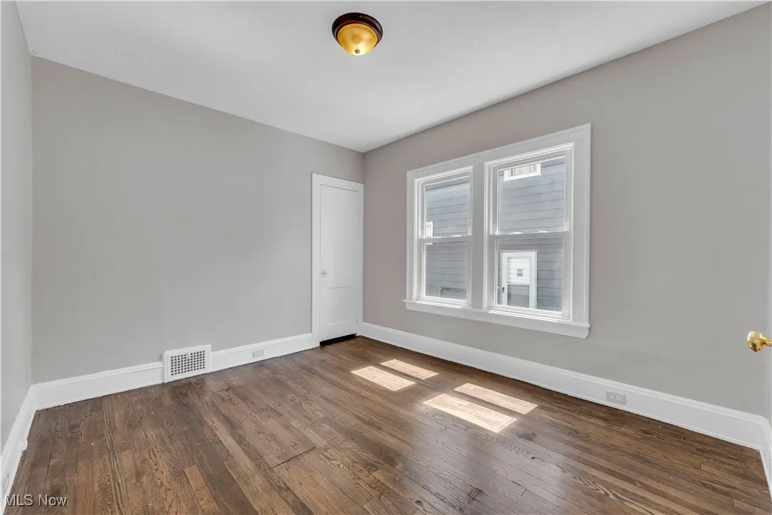 Spare room featuring dark wood-style floors