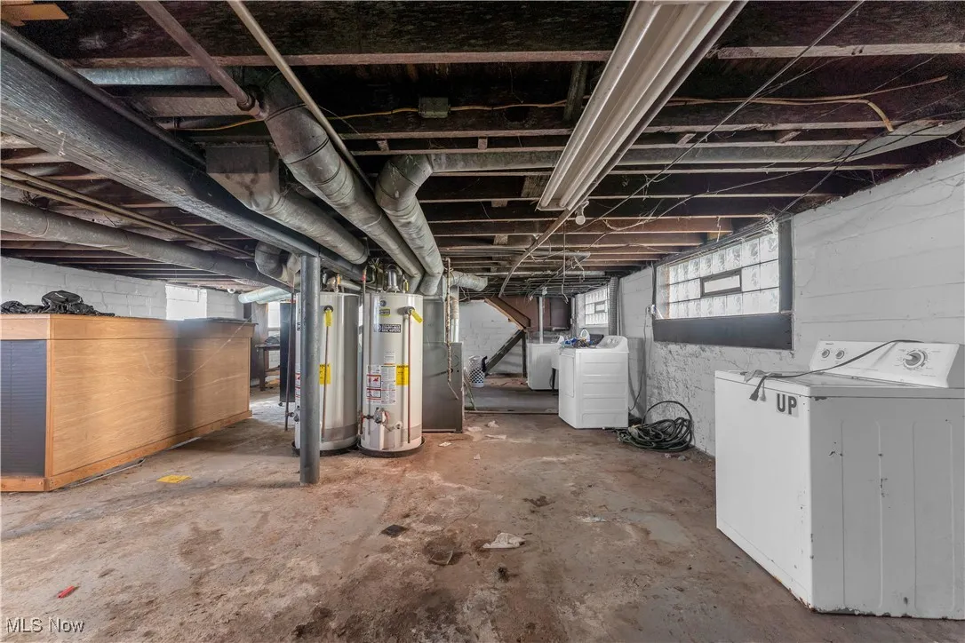 Basement with gas water heater, separate washer and dryer, and heating unit