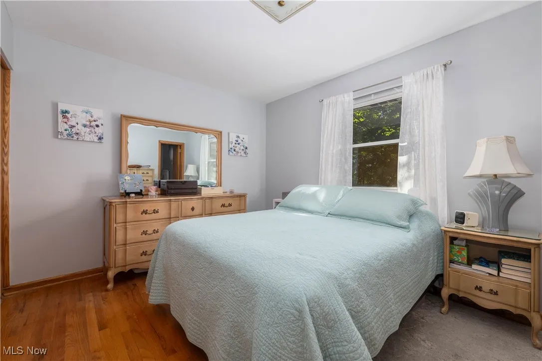 Bedroom with wood finished floors and baseboards
