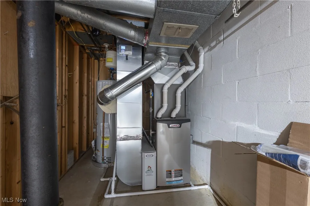 Utility room featuring gas water heater and heating unit