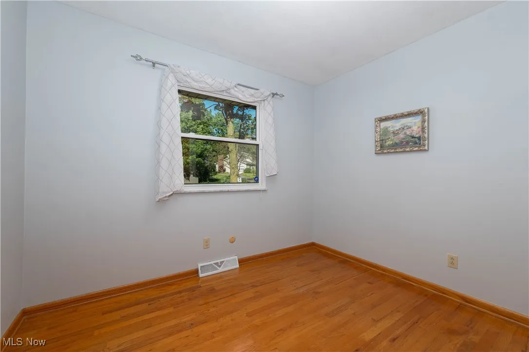 Unfurnished room with light wood-style flooring and baseboards
