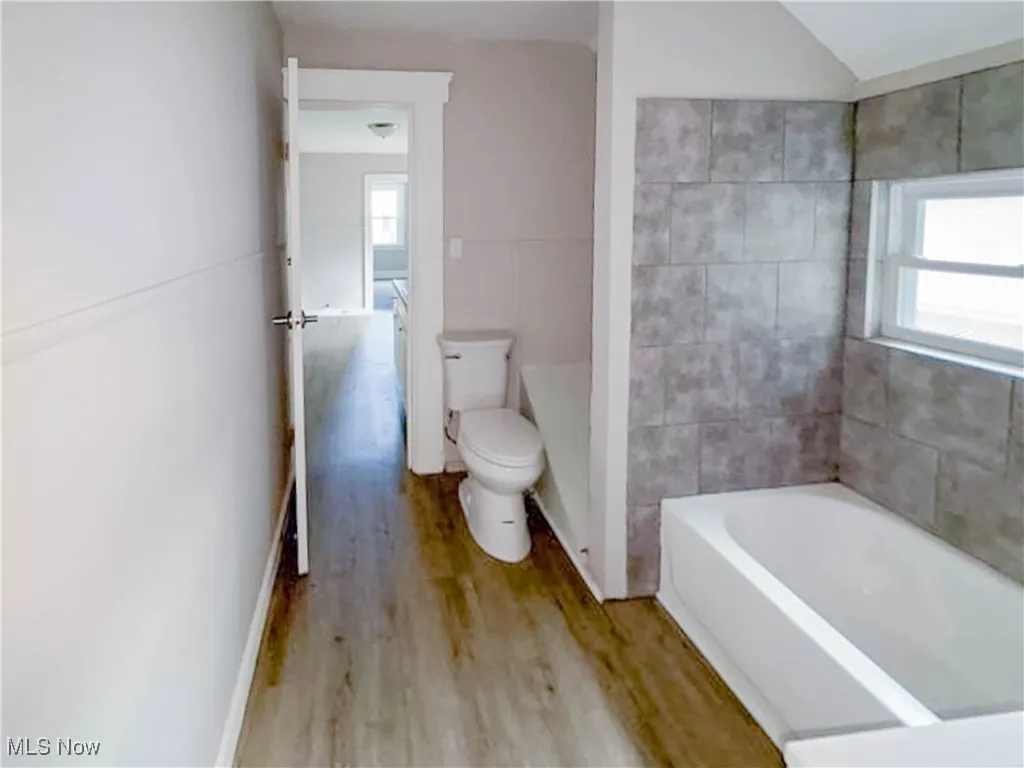 Bathroom with bathing tub / shower combination, vanity, and vaulted ceiling