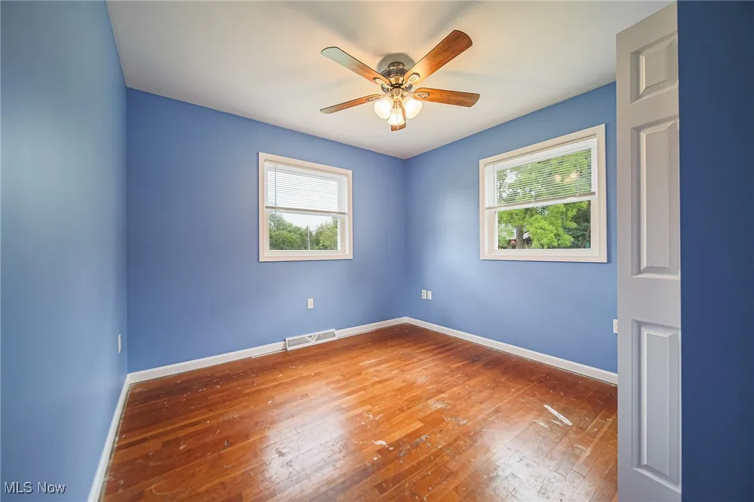 Bedroom with hardwood / wood-style flooring, plenty of natural light, and a ceiling fan