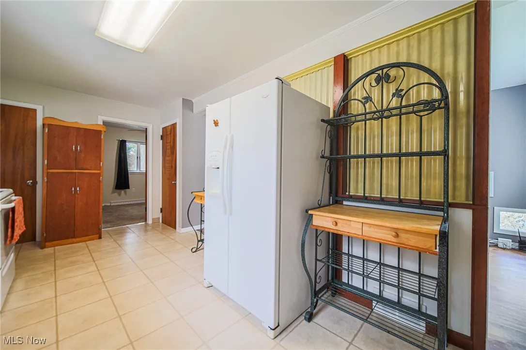 Corridor featuring light tile patterned floors and baseboards
