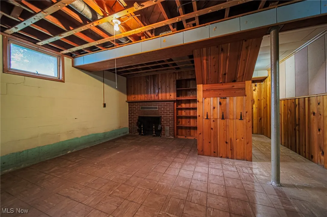Below grade area featuring a fireplace and wood walls