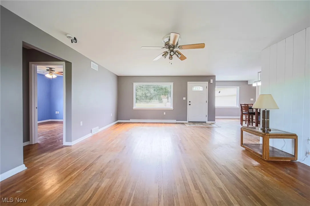 Unfurnished living room with ceiling fan and light wood-style flooring