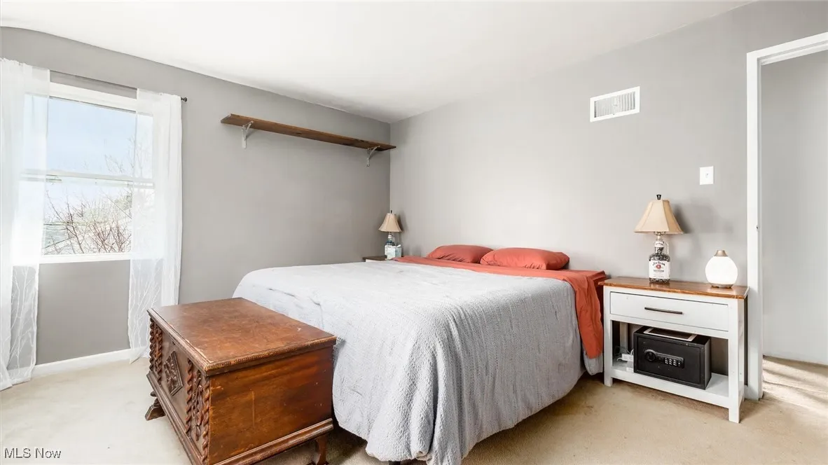 Bedroom with light carpet and baseboards