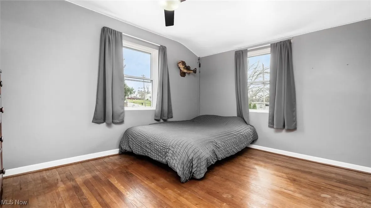 Bedroom featuring hardwood / wood-style floors, vaulted ceiling, and ceiling fan