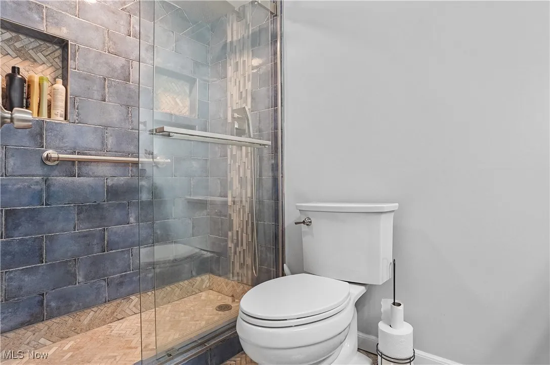 hall Bathroom featuring tile shower and rain shower head