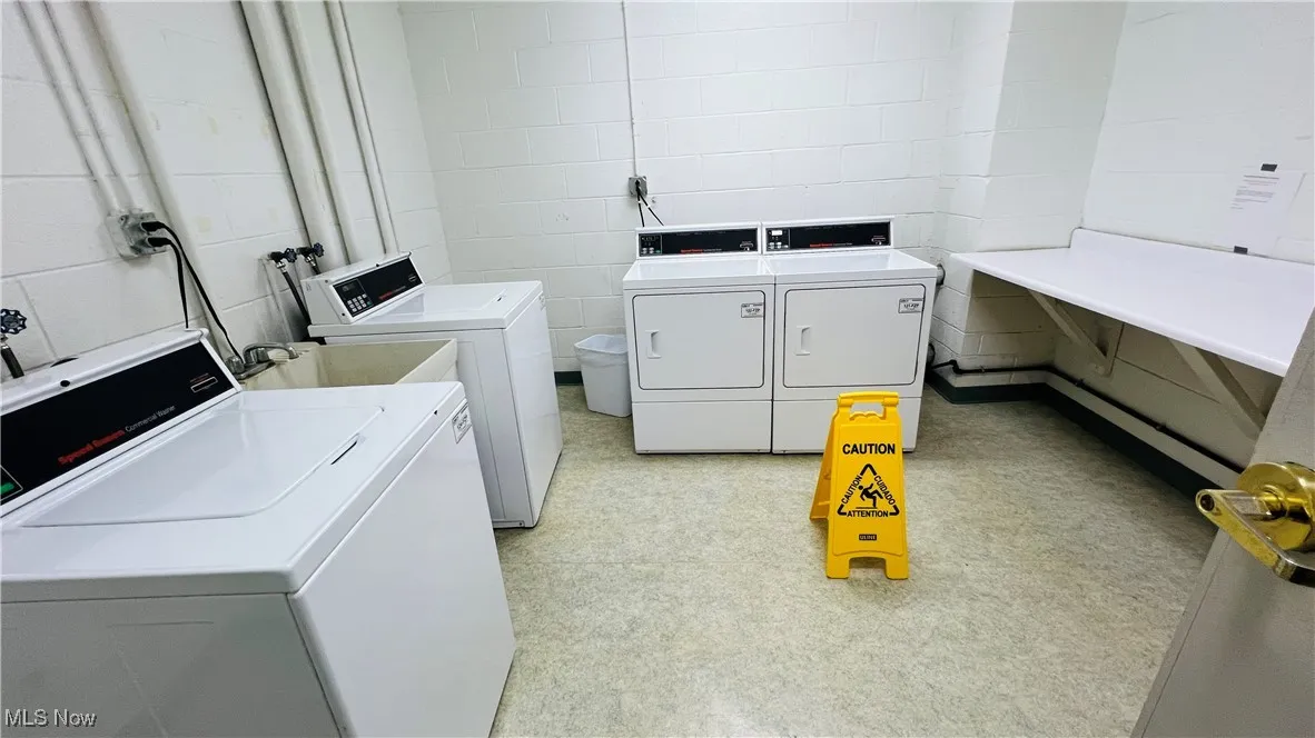 Community laundry featuring separate washer and dryer and folding area
