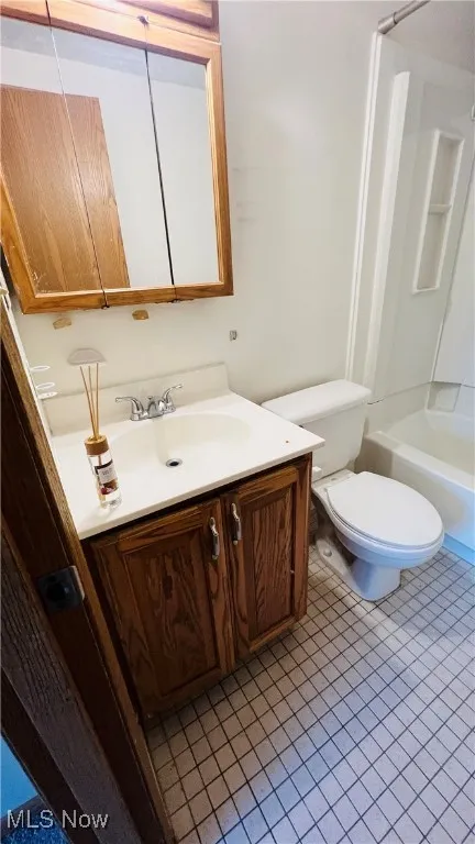 Full bath featuring tile patterned floors, vanity, and bathtub / shower combination