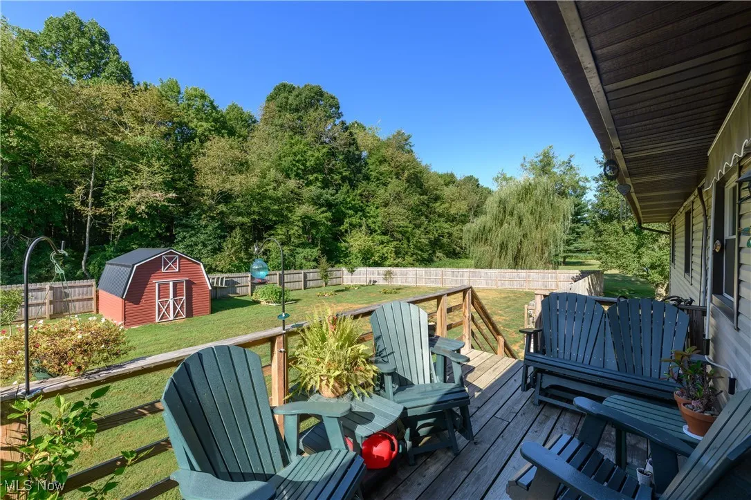 Deck with a fenced backyard and a storage unit