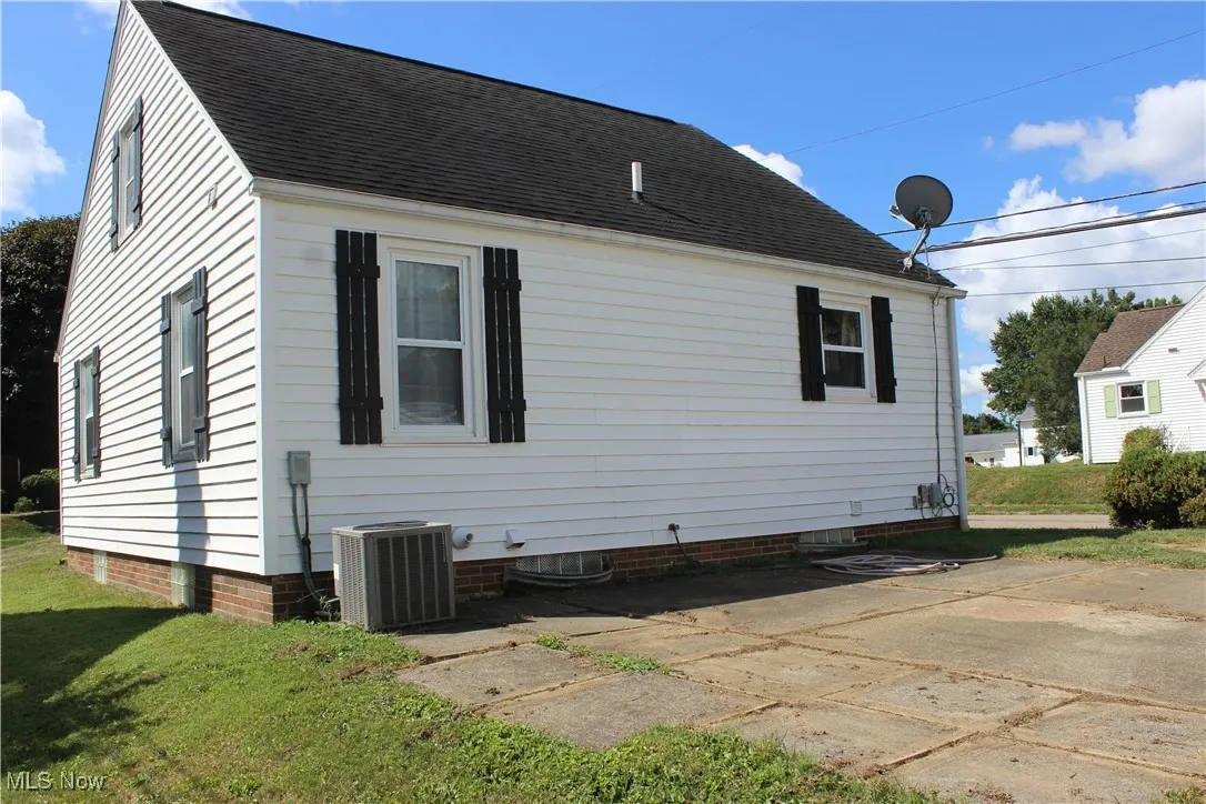 View of property exterior featuring a shingled roof and a yard