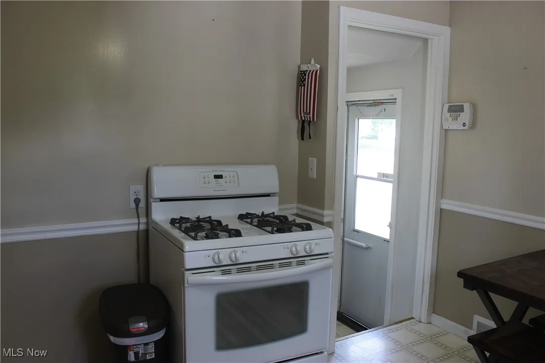 Kitchen with white gas range and light flooring