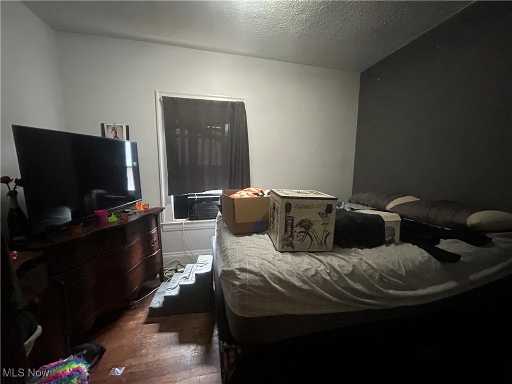 Bedroom featuring a textured ceiling and dark wood-style floors