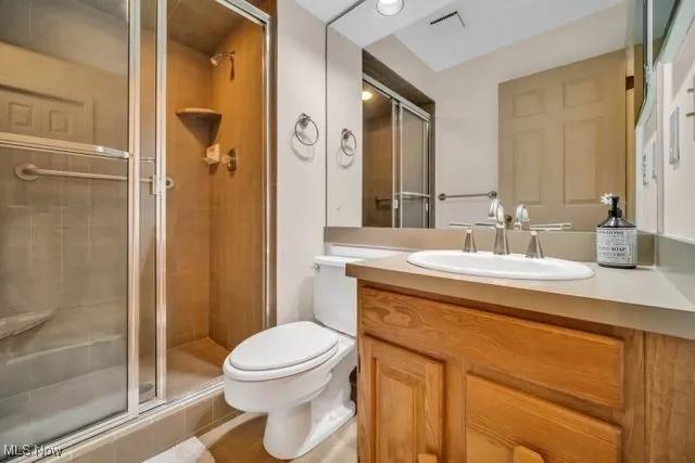 Bathroom with vanity, an enclosed shower, and toilet  This can serve as private bathroom for the flex room, a powder room or a second bathroom for his/her bathrooms
