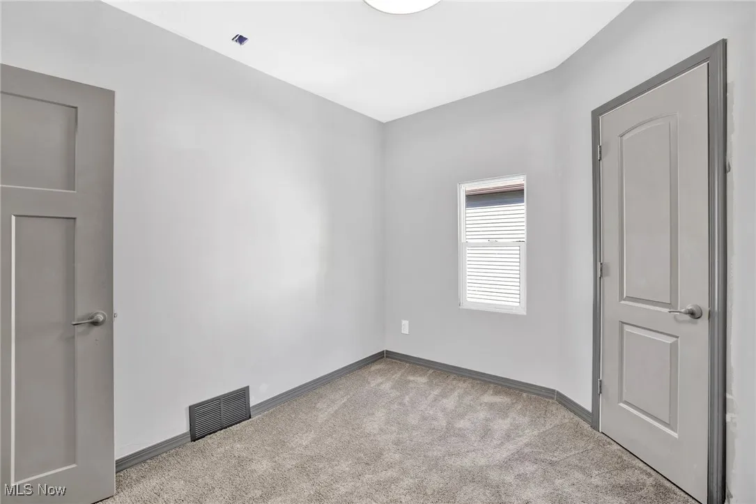 Unfurnished bedroom with carpet floors and baseboards