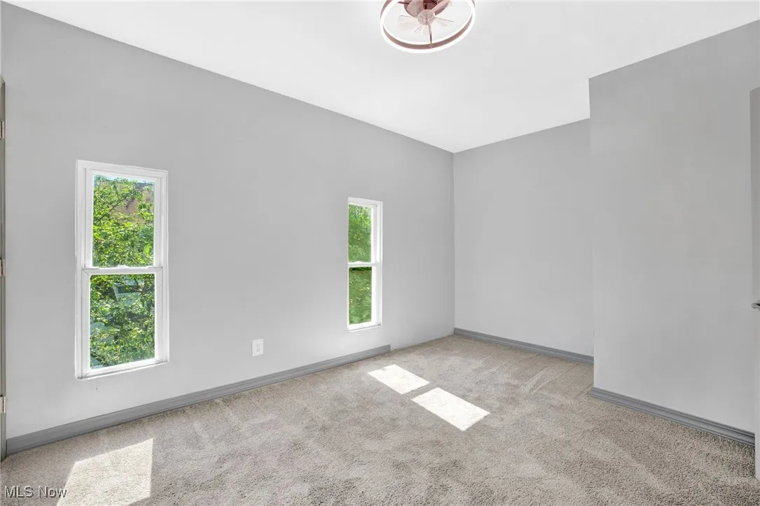 Empty room featuring light carpet and baseboards