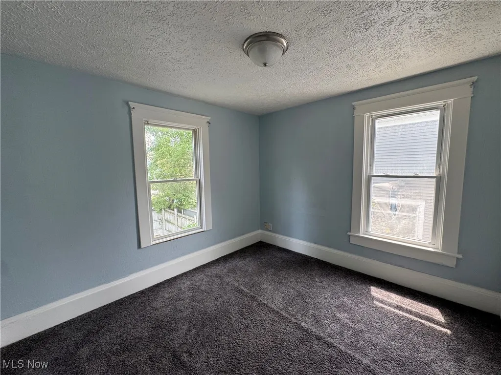 Bedroom 2 with carpet floors and a textured ceiling
