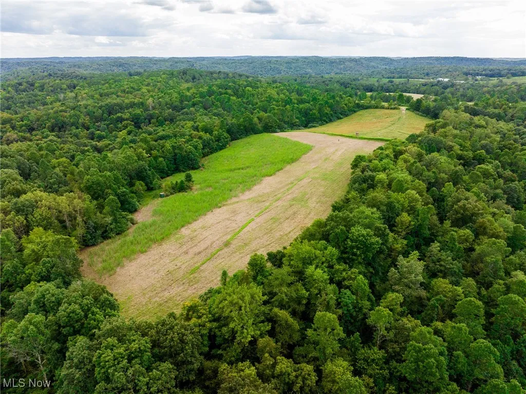 Overview of rural landscape featuring a heavily wooded area