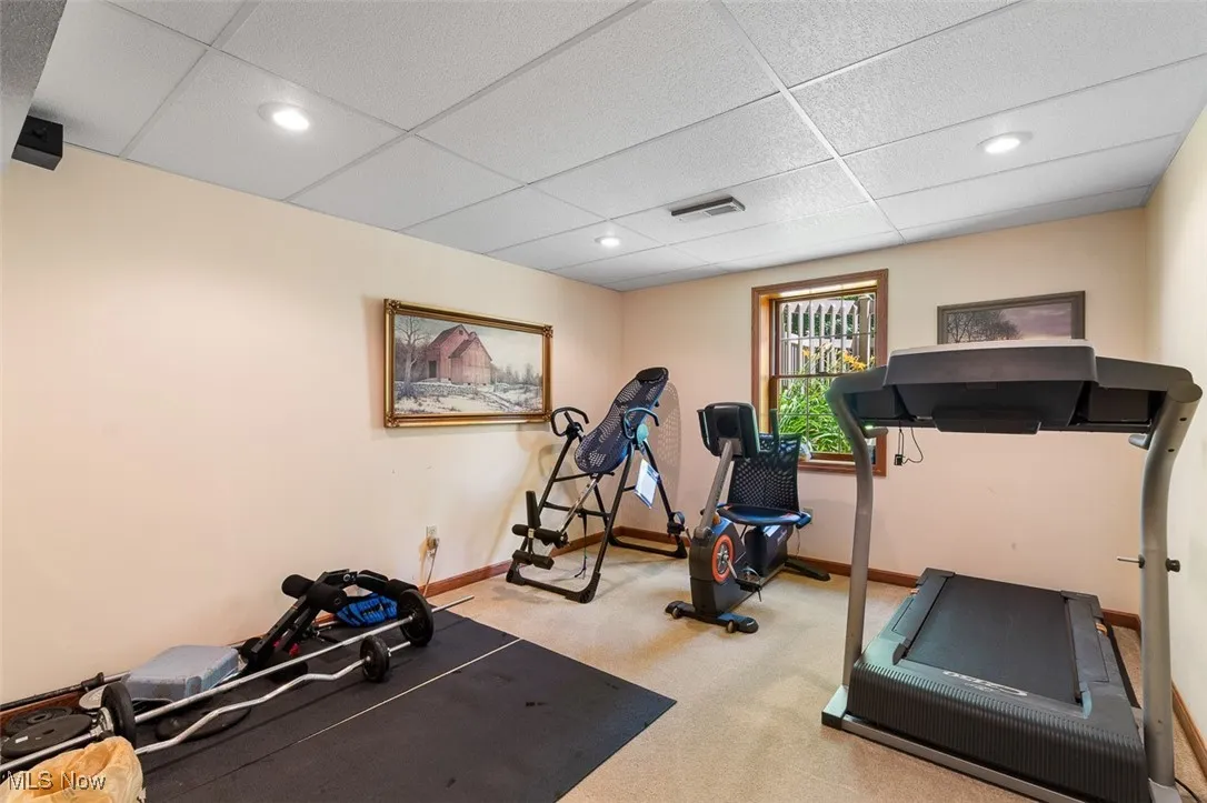 Exercise area with a paneled ceiling, carpet, and recessed lighting