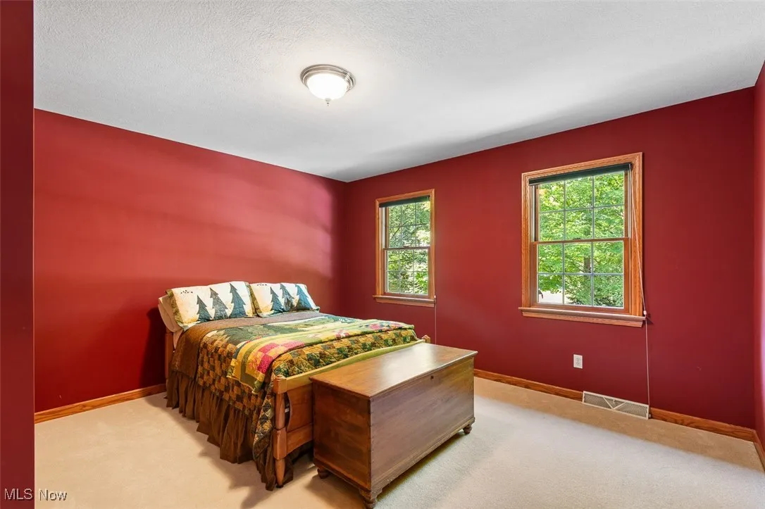 Carpeted bedroom with baseboards and a textured ceiling