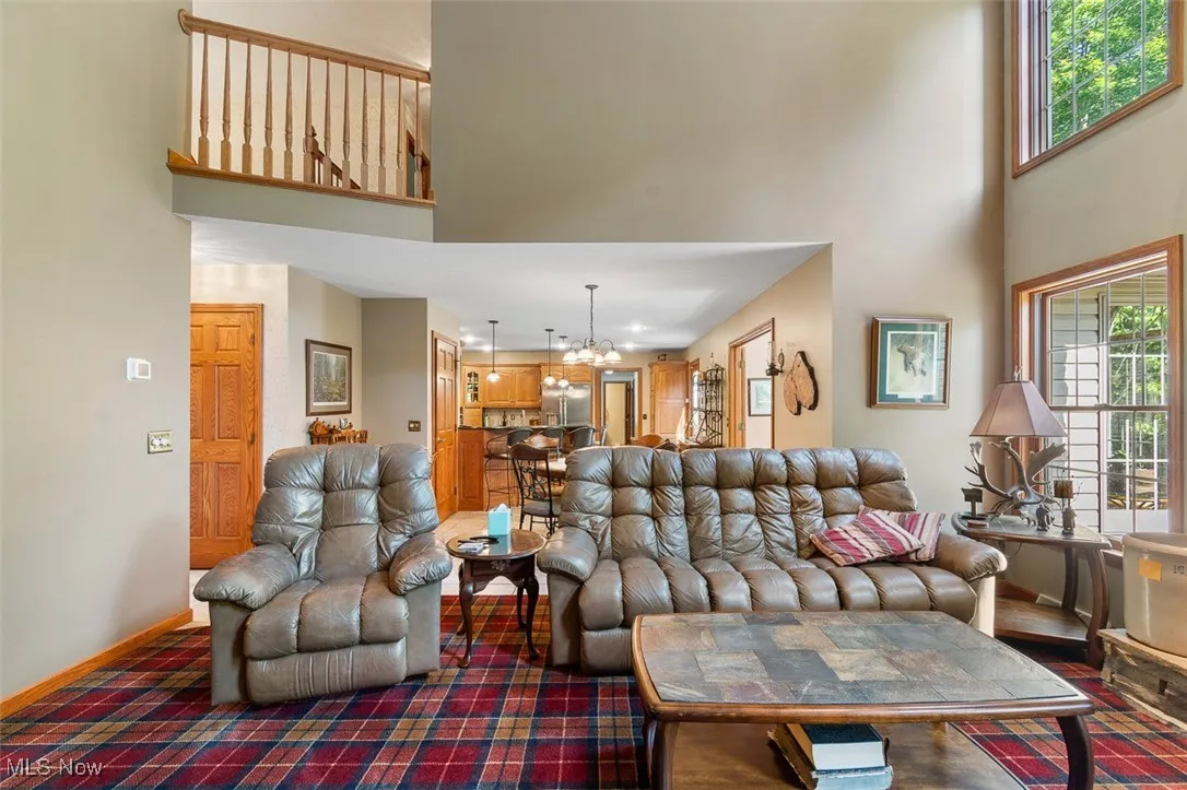 Living area featuring a high ceiling and a chandelier