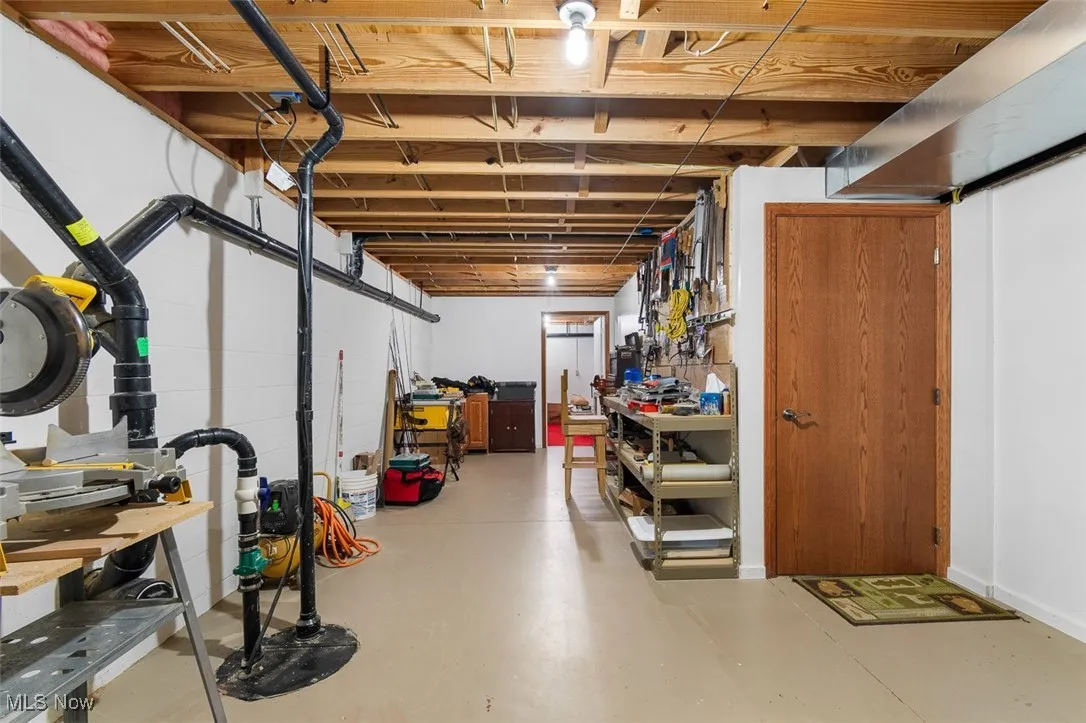 Unfinished below grade area with drainage system and a workshop area