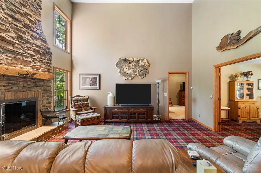 Living room with a towering ceiling and a stone fireplace