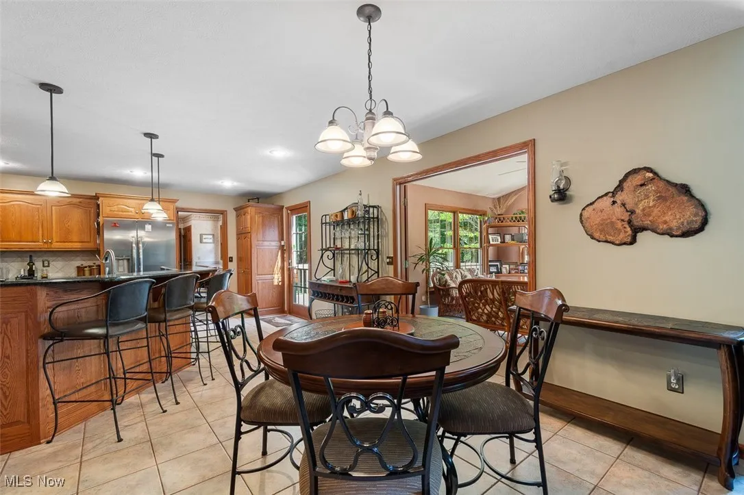 Dining space with light tile patterned floors and a chandelier