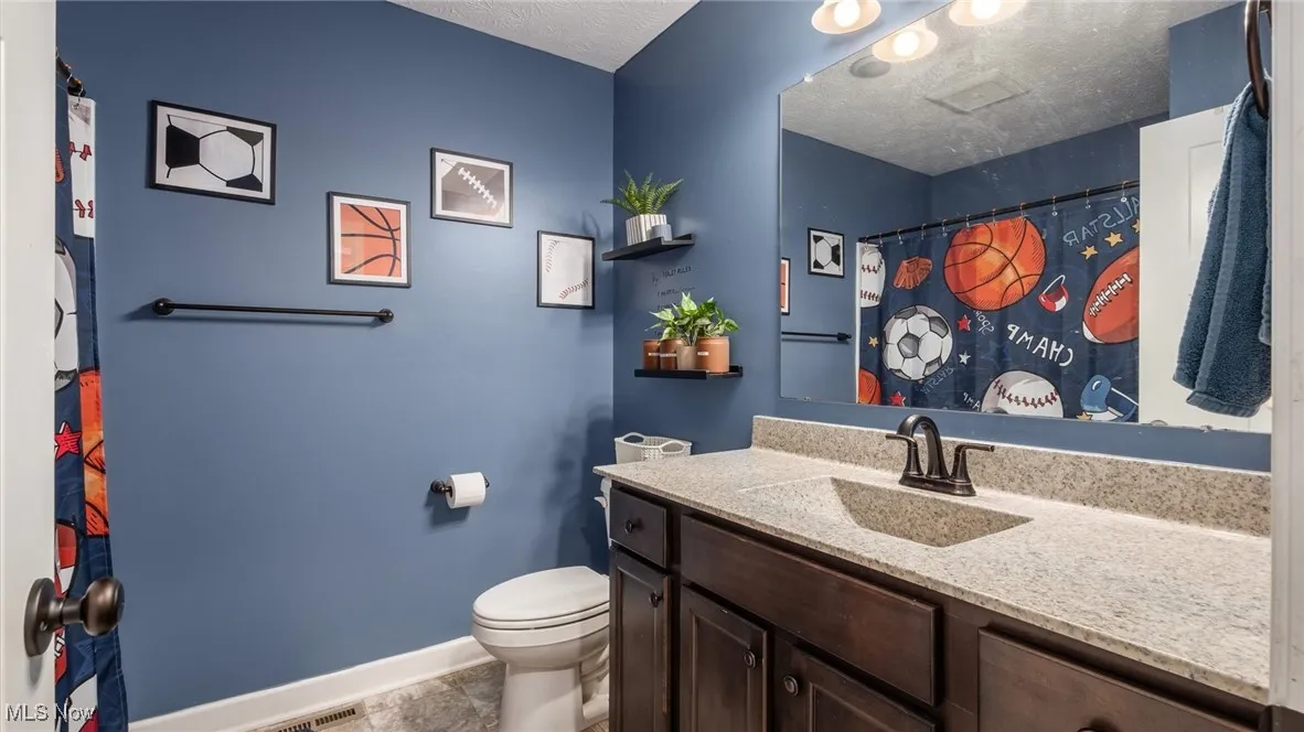 Full bathroom featuring vanity, a textured ceiling, and curtained shower